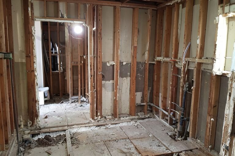 Gutted bathroom down to wall studs and subfloor ready for renovation rebuild