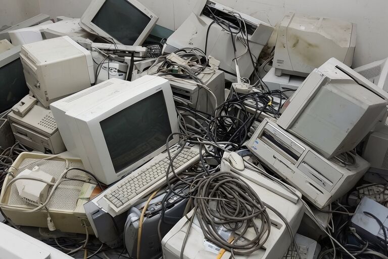 Old electronics including CRT monitors computers and printers piled for recycling
