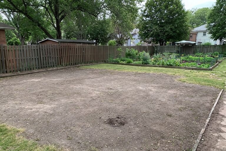 Clean open backyard area where a garden shed used to stand after removal